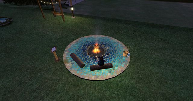 The fire pit from above at night, on its floor of sea-coloured mosaic tiles.